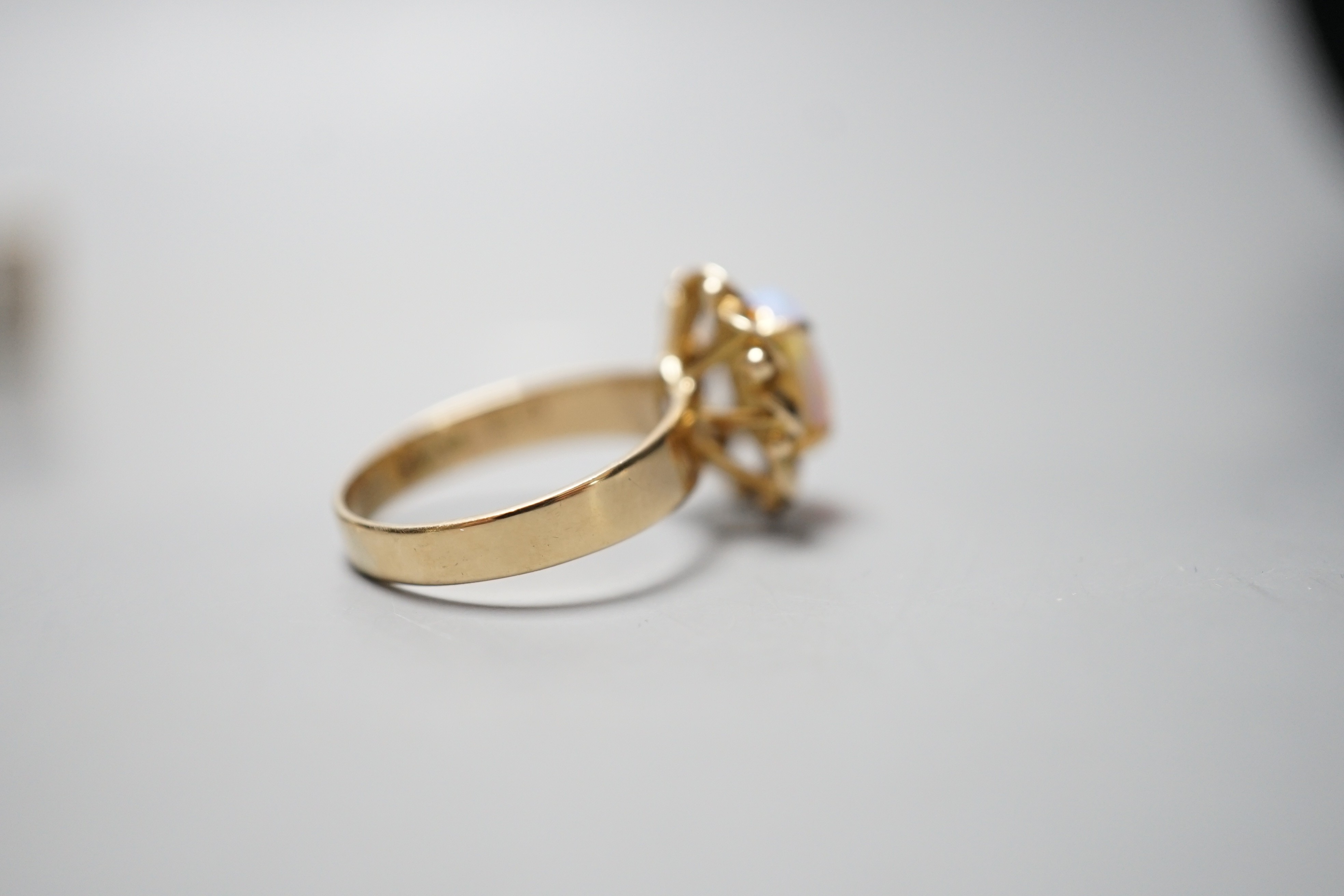 A 14k yellow metal and white opal set oval dress ring, size O, gross weight 3.9 grams.